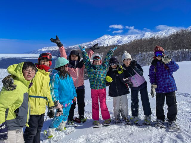 世界自然遺産・知床で冬の原生林トレッキングをする小学生と中学生