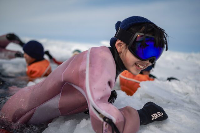 世界自然遺産・知床の流氷で遊ぶ小学生と中学生