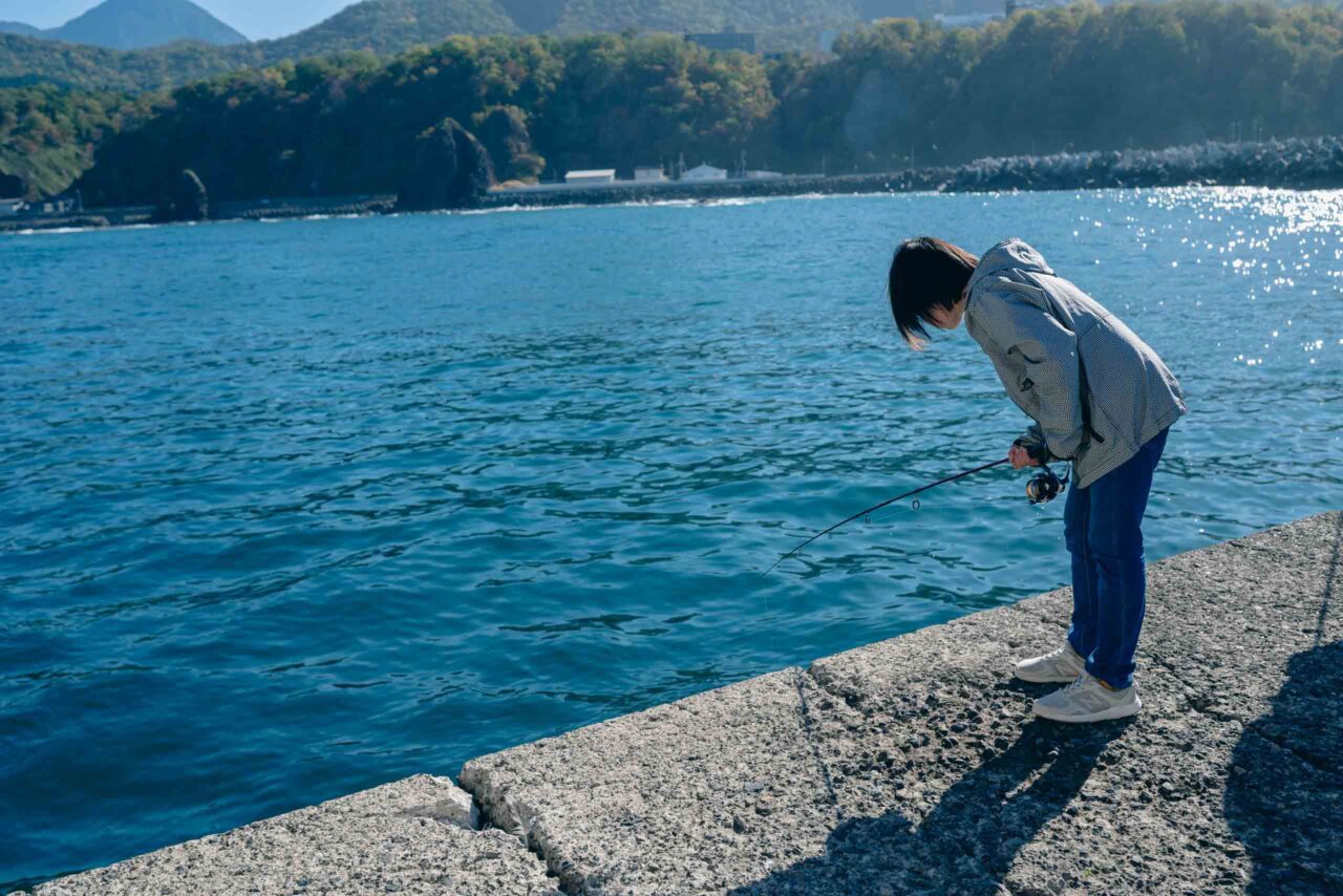 ウトロ漁港で釣りをする小学生と中学生